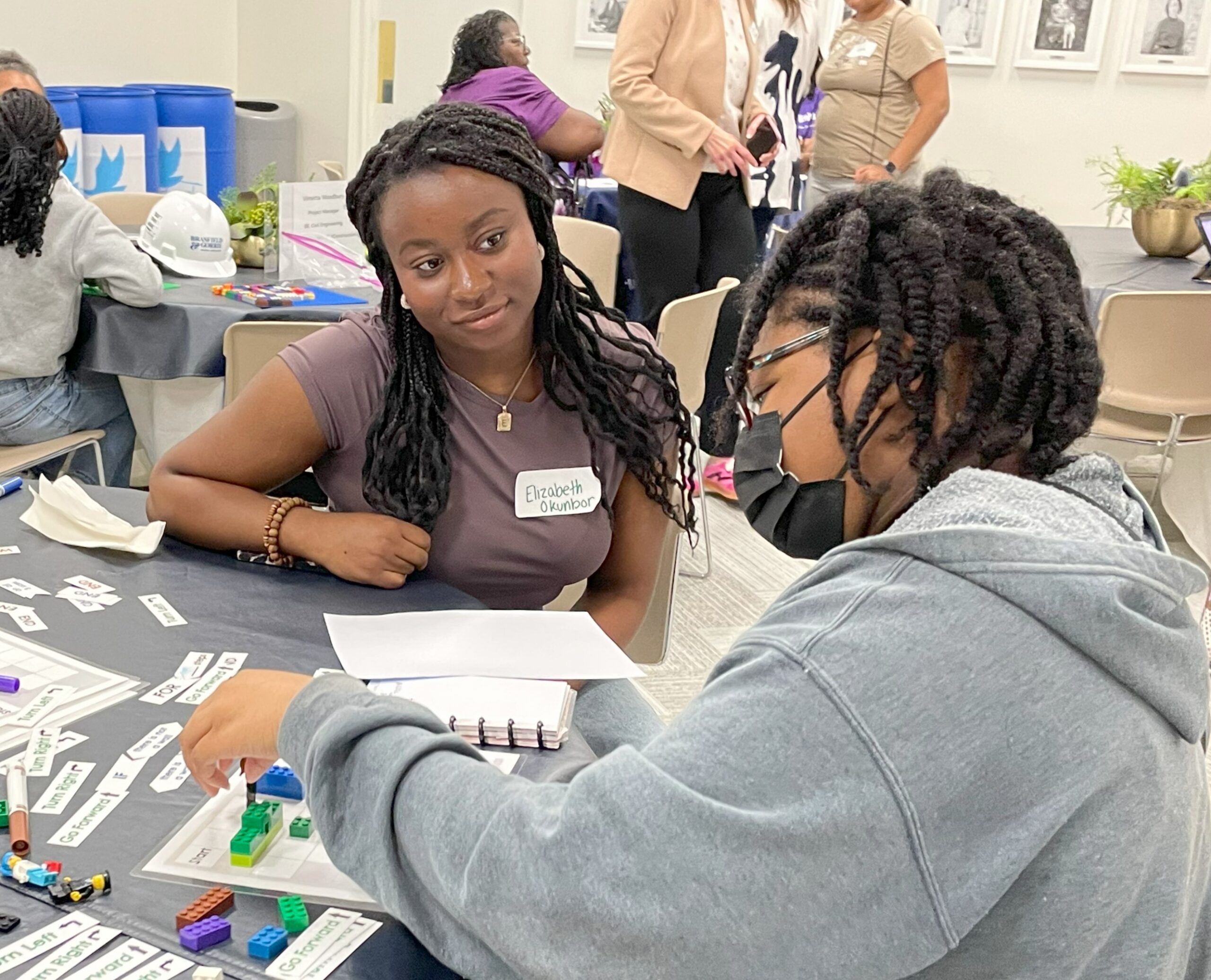 Elizabeth Okunbor helping a student with a lego activity.